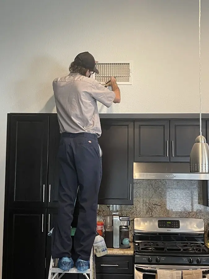 Technician inspecting an air vent during HVAC service in Pevely